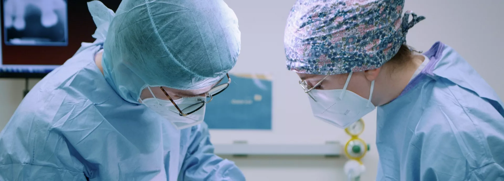 Visuel de transition : 2 médecins sont en train d'opérer un patient