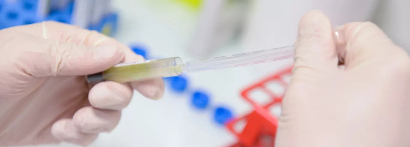 Visuel d'illustration d'un laborantin manipulant un échantillon avec un tube à essai