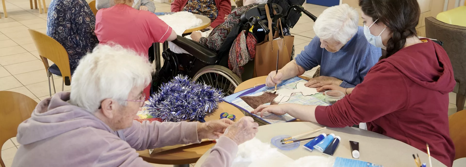 Des personnes âgées font un atelier d'art thérapie avec des accompagnantes