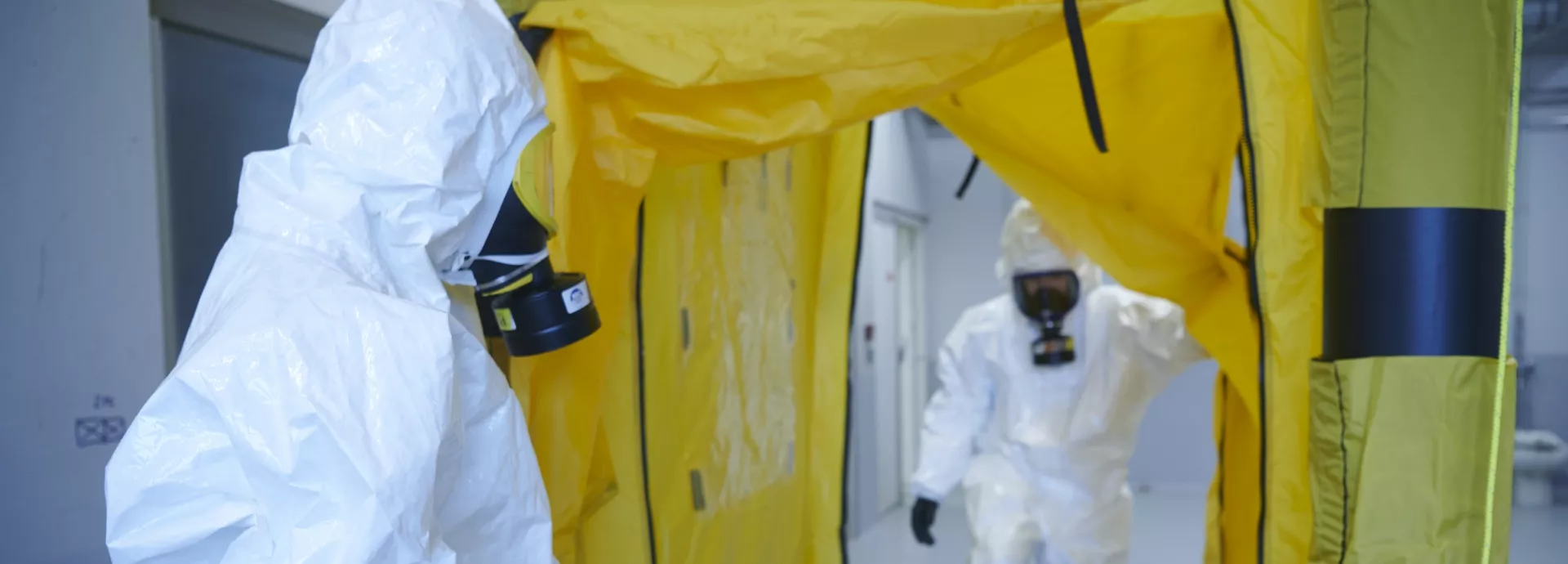 une personne en tenue complete entre dans une tente sterile