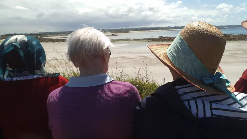trois personnes âgées face à la plage
