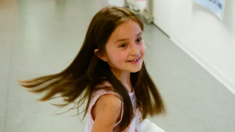 petite fille tournoie dans un couloir