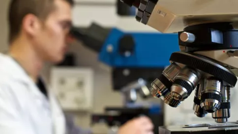 Homme qui regarde dans un microscope