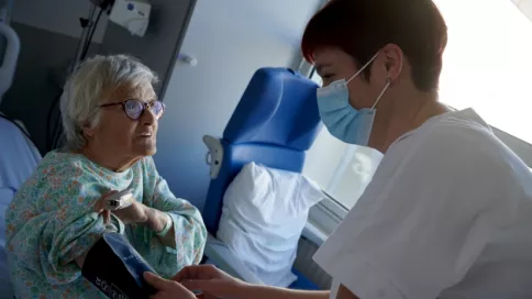 Une infirmière prend la tension d'une femme âgée